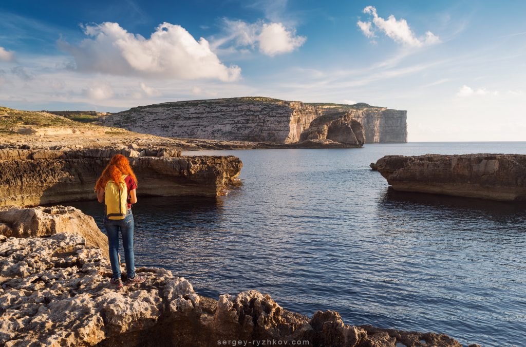 Red-haired girl enjoying majestic Mediterranean coastline. Gozo Island, Malta